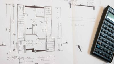 Architectural blueprint with measurements and a calculator on the side.