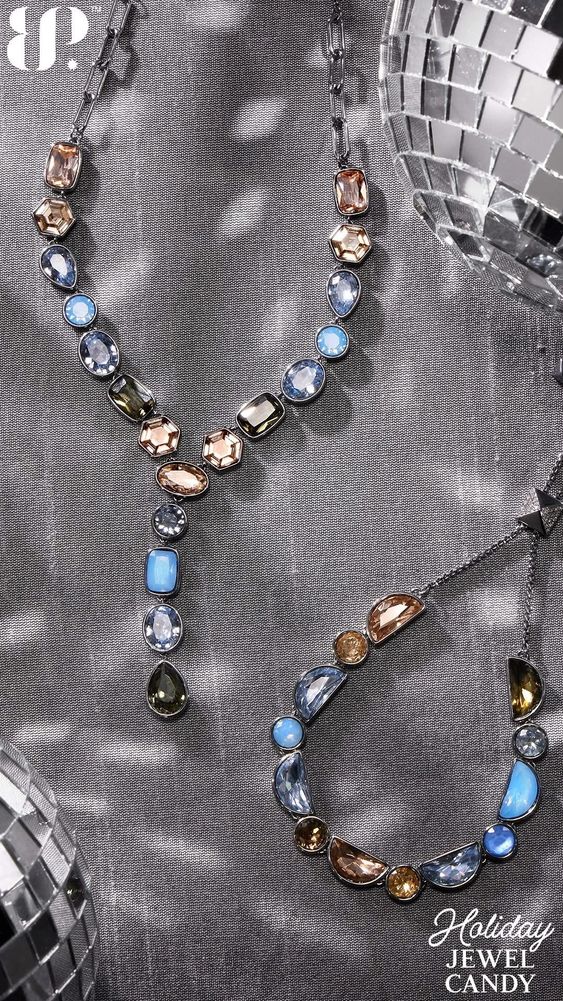 Elegant necklaces with multicolored gemstones on a textured grey background.