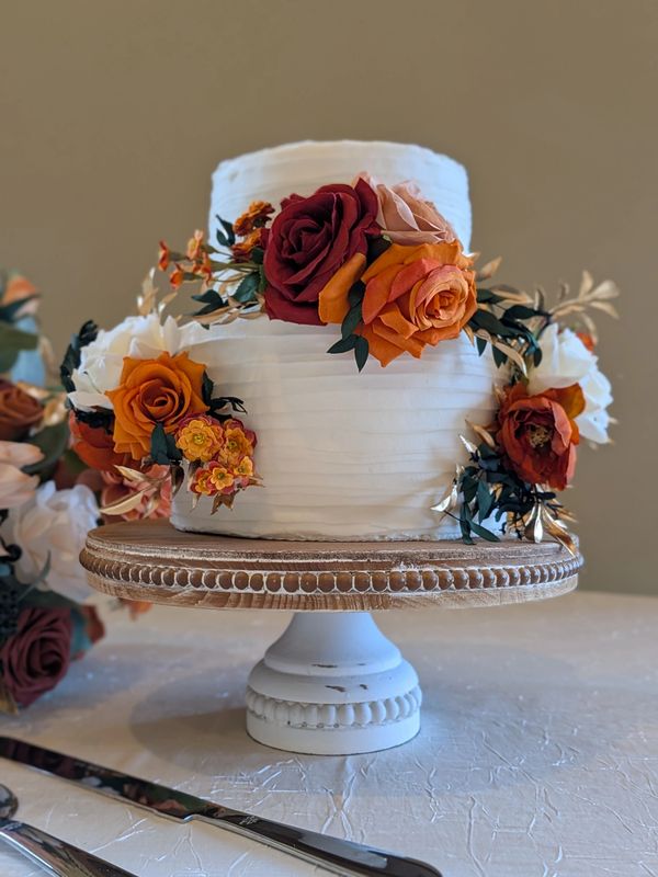 6-inch 3-layer cake on 8-inch 3-layer cake, vanilla textured frosting, flowers added