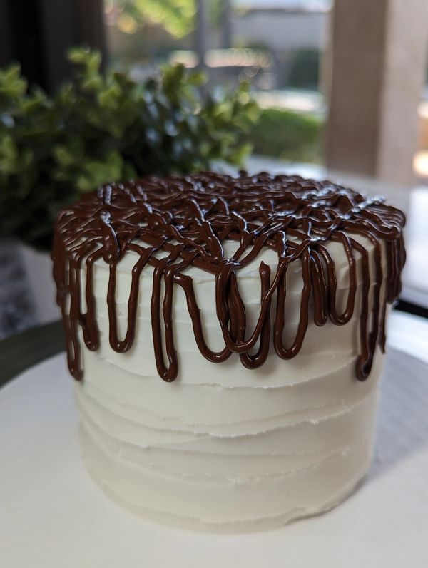 4-inch 3-layer cake, vanilla textured frosting, thick chocolate glaze drizzle