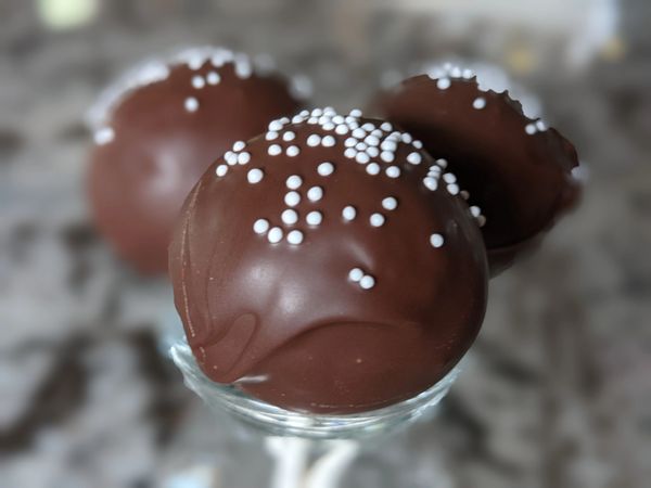 Chocolate chip cake pop, chocolate candy coating, white nonpareils
