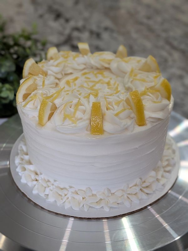 6-inch (3-layer) lemon cake, lemon textured frosting, rosette top border with fresh lemons and zest
