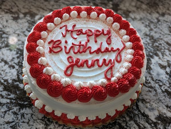 10-inch cake, vanilla textured frosting, small red swirl border with white stars