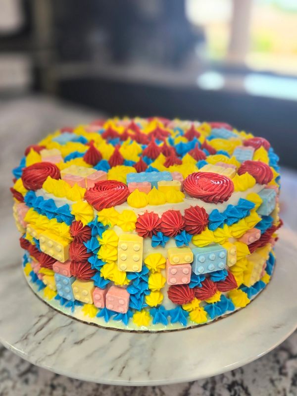 8 inch 2 layer vanilla cake, vanilla frosting, candy blocks (like Legos), colored frosting