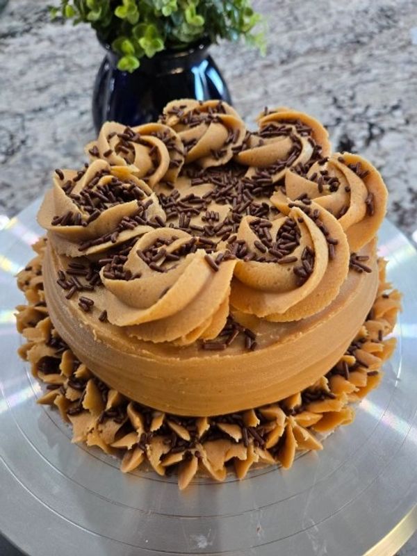 6-inch chocolate cake, peanut butter textured frosting, large rosettes/flowers, chocolate sprinkles