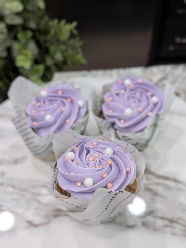 Marble cupcakes, purple vanilla frosting in a large rosette, pink and white pearls