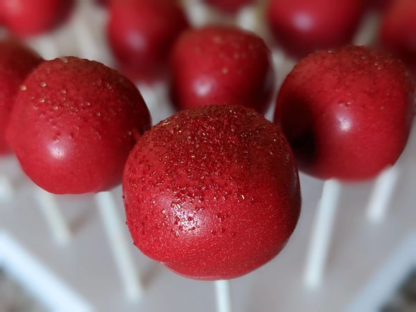 Red velvet cake pop, vanilla candy coating in red, red sprinkles
