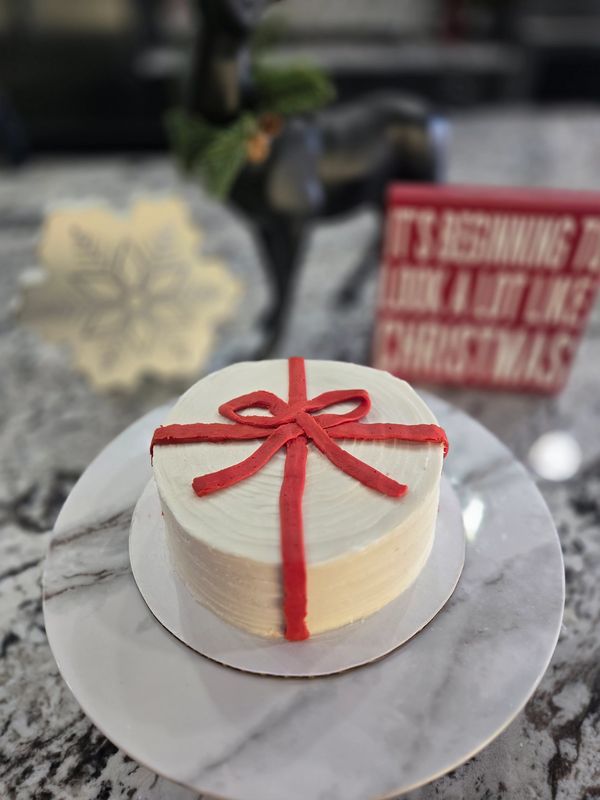 6-inch (2 layer) gingerbread cake, vanilla textured frosting, red ribbon