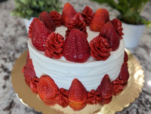 8-inch cake, vanilla textured frosting, red swirl top border with fresh strawberries