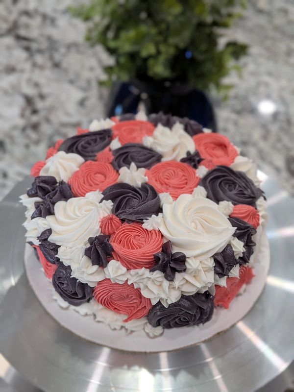 6-inch chocolate cake, white, pink & purple rosettes covering top and sides, flower accents