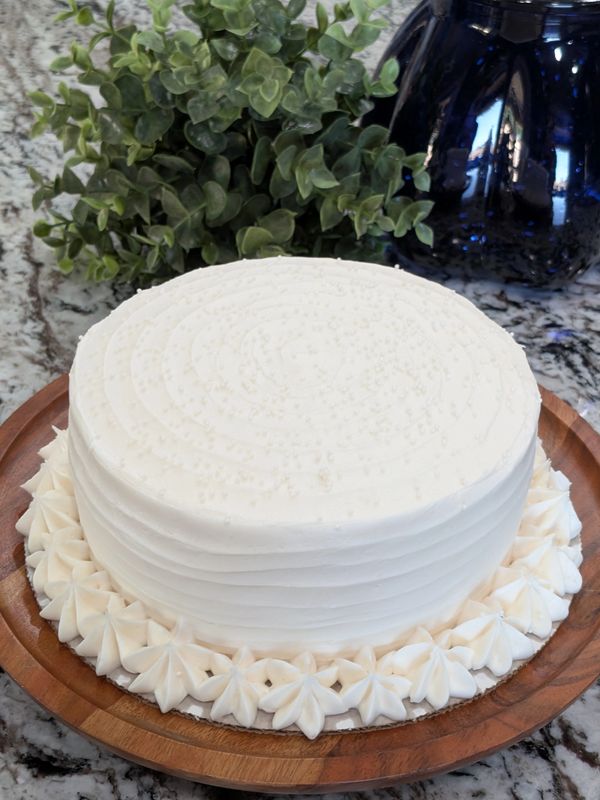 6-inch vanilla in-stock cake, vanilla textured frosting, star bottom border, white nonpareils