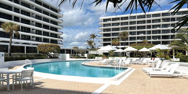 Beach Point pool deck with white umbrellas, 2660 S Ocean, Palm Beach, condos for sale