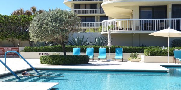 Meridian, 3300 South Ocean Blvd., Palm Beach, condos for sale, pool with four blue chairs