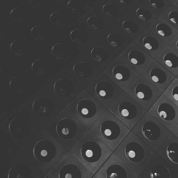 Black and white geometric pattern with circular indents in a grid.