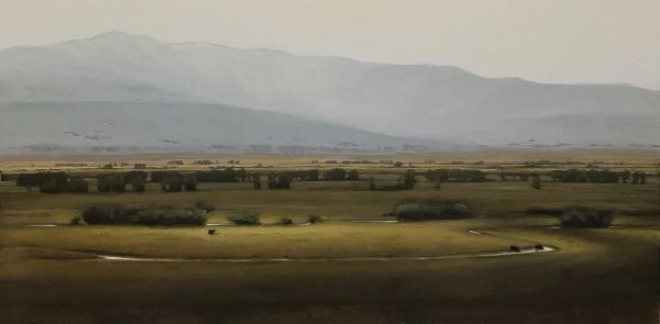 Scenic rural landscape with distant mountains and a winding dirt road.