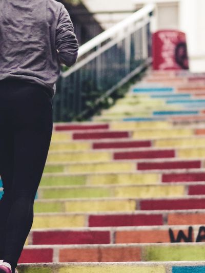 A Woman Running Up a Colorful Stairs