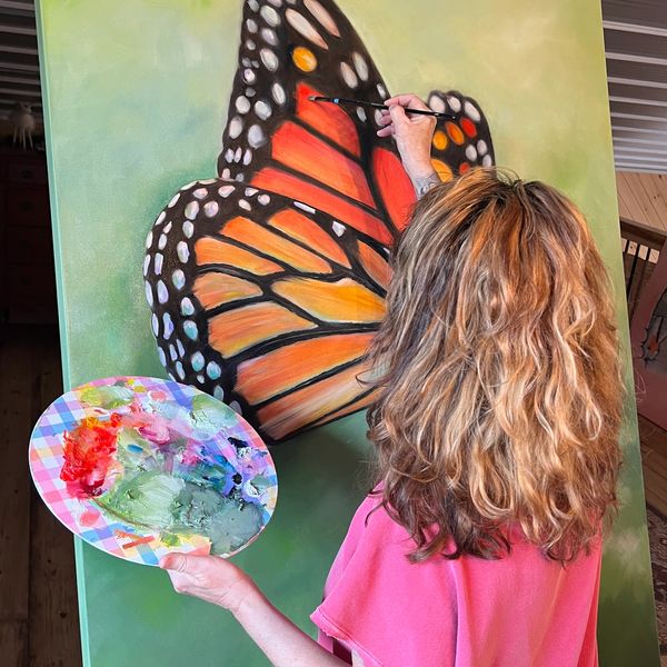 woman painting a monarch butterfly