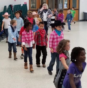2nd Grade Students promenade their partners around the floor.