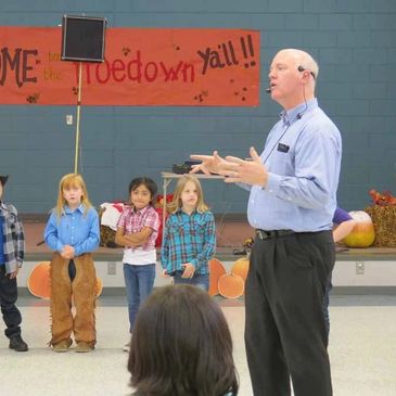 Carl instructs students at 2nd Grade Hoedown