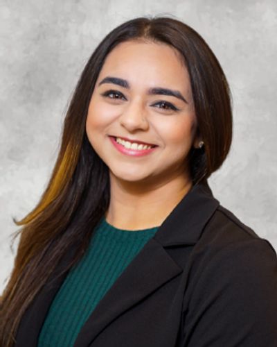 Smiling woman with long dark hair in a professional black blazer.