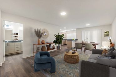Modern living room with blue chair, gray sofa, and wooden dining table in a bright, open space.