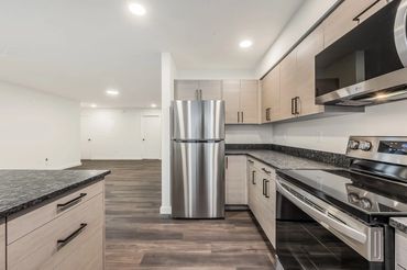 Modern kitchen with stainless steel appliances and light wood cabinets.