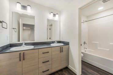 Modern bathroom with dual sinks and a bathtub.