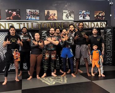 Group of martial artists posing inside a training gym.