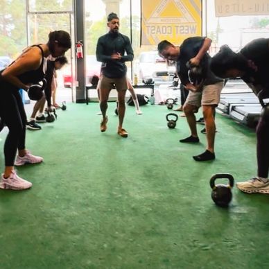 Group workout session with kettlebells in a gym.