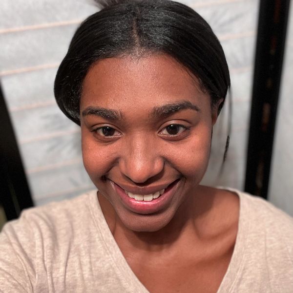 A smiling woman with smooth skin and neatly styled hair.