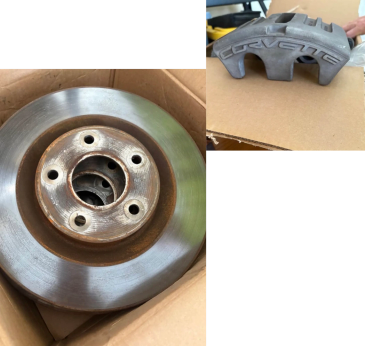Car brake rotor and Corvette brake caliper on a cardboard box.