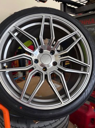 Close-up of a stylish multi-spoke car wheel and tire.