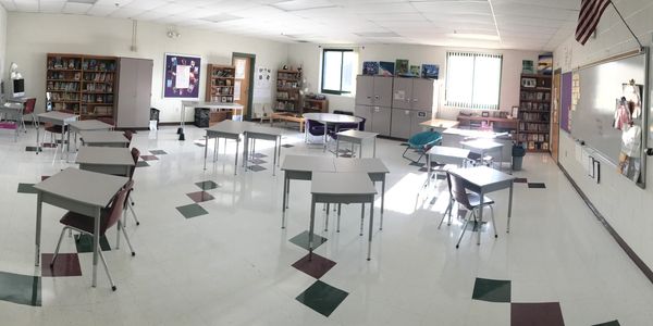 Classroom with desks, natural light, tons of books, flexible seating