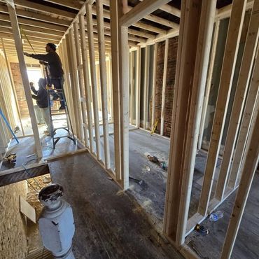 Construction workers installing wooden frames inside a building under renovation.