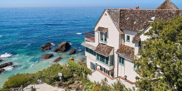 A coastal house overlooking the ocean with rocky shores.