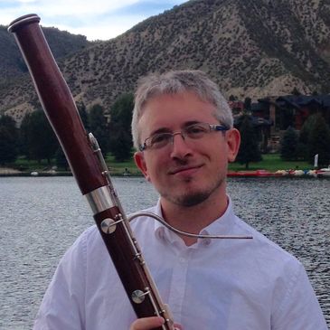 Daniel Nester holding his bassoon in the beautiful mountains