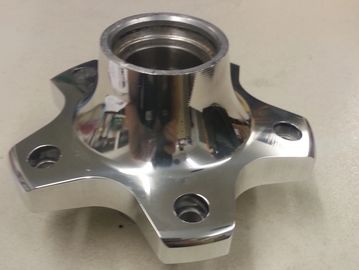 Polished metal automotive hub with four mounting holes.