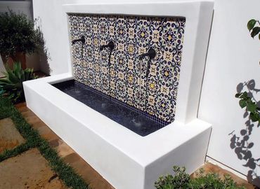 Spanish style tiles and triple spout fountain adds beauty to the backyard