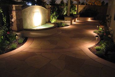 hardscape on custom waterfall fountain and pathway with landscaping and lighting design