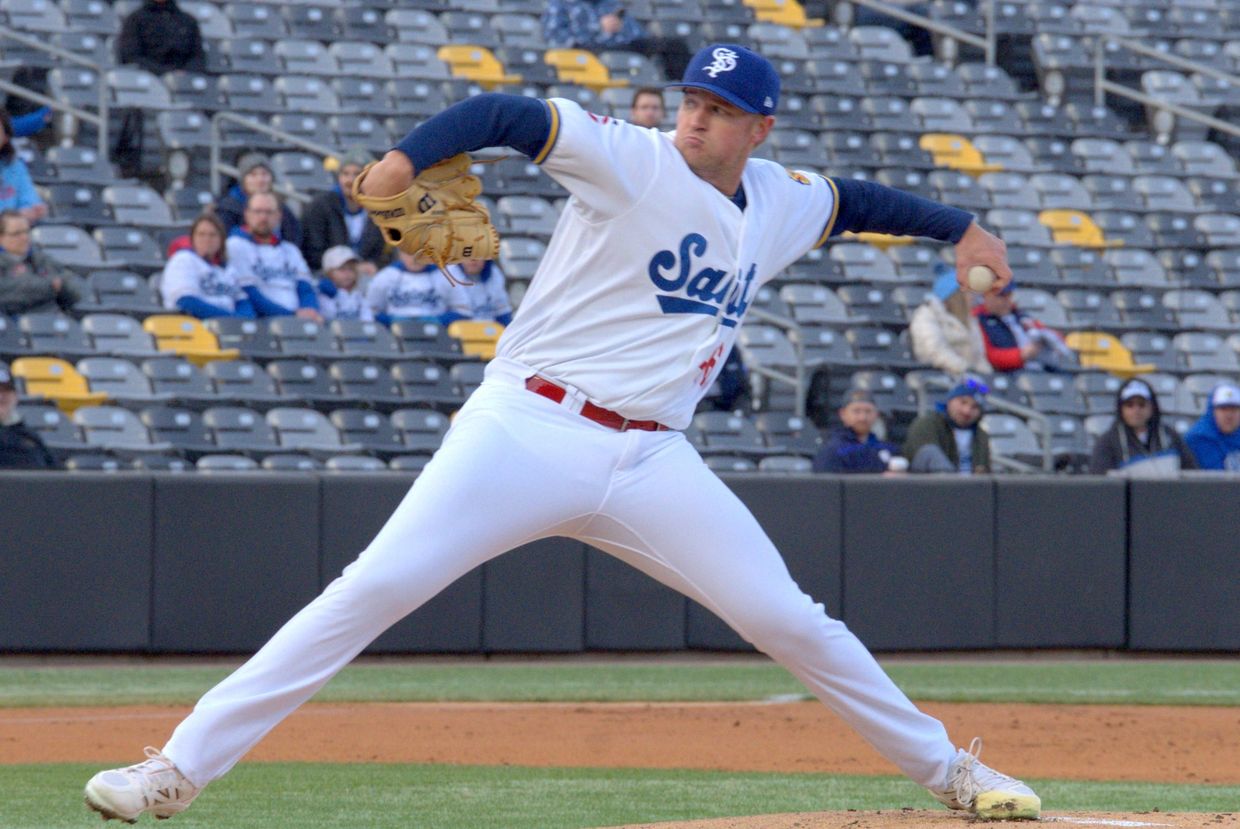 Baseball pitcher in mid-throw during a game.