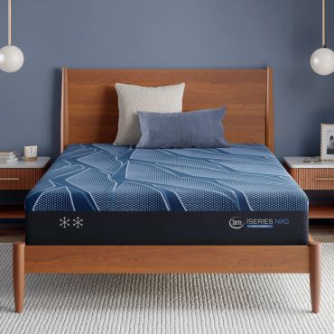 Wooden bed with blue bedding and pillows in a cozy bedroom.