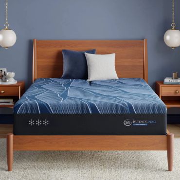 Modern bed with blue-themed bedding and wooden frame.