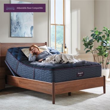 Woman relaxing on an adjustable base compatible mattress in a cozy bedroom.