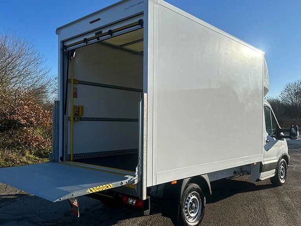 White delivery truck with open rear loading ramp.