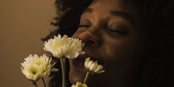 Woman smelling white flowers