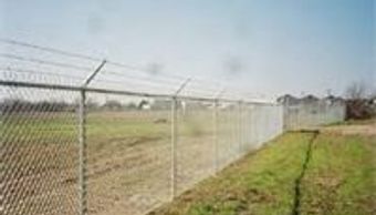 Six foot tall commercial grade chain link fence in Austin with 3 strands of barbed wire on top