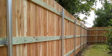 Three rail privacy fence using 2 3/8" galvanized steel posts and 4" wide cedar pickets in Austin