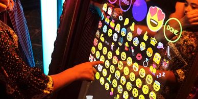 Quinceanera adding emojii to their photo on the mirror photobooth.