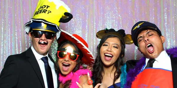 friends using silly props having fun with magic mirror photobooth