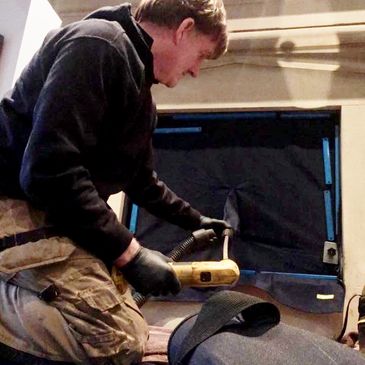 John Chadwick cleaning and sweeping fireplace